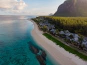 Aerial photograph of a tranquil beach resort in Mauritius with clear waters and lush greenery.